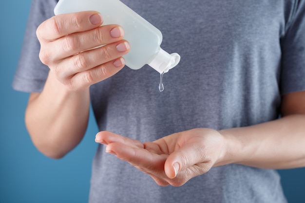 Close-up of a girl holding a Disinfectant gel in her hands. Antiseptic treatment of hands from bacteria Sanitizer.