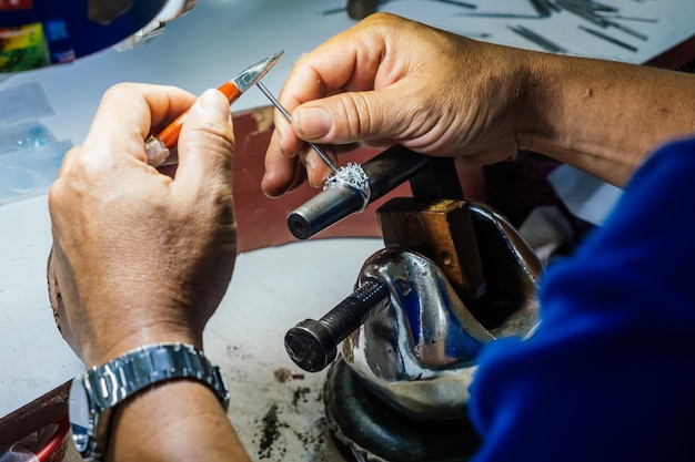 Close up of a goldsmith's hand making silver ring.