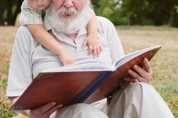 Close-up grandpa and grandson reading