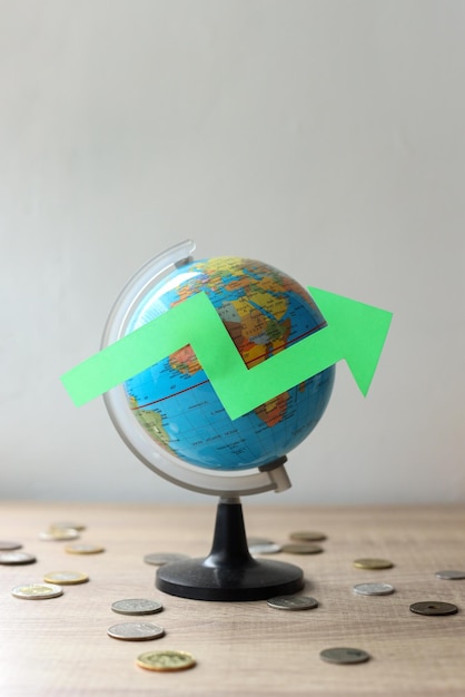 Close-up of green arrow up on world  globe. Global financial concept.