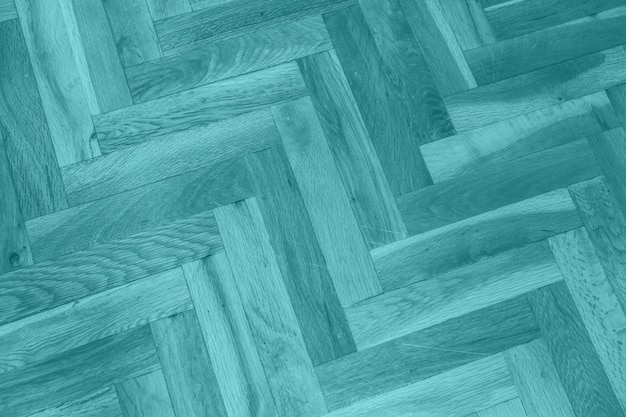 A close up of a green parquet floor with a wooden parquet flooring pattern.