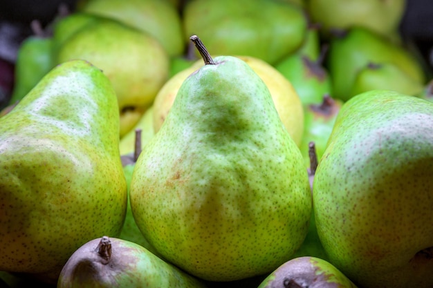 Close up green pears in wooden boxes sale in supermarket