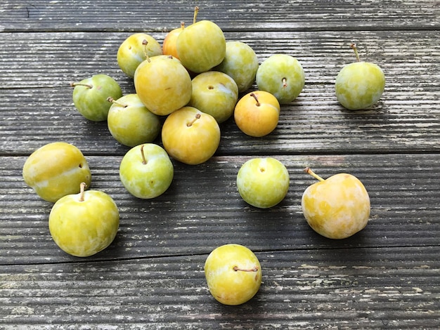 Photo close-up of greengages on wooden plank