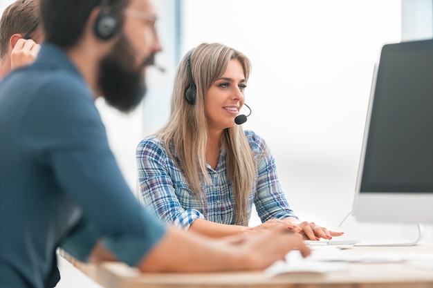 Close up. a group of employees in a headset sitting at a Desk