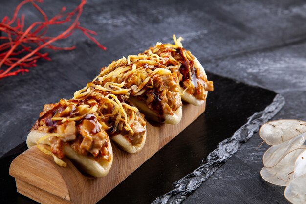 Close up on Gua bao, steamed buns with meat. Bao served with tasty topping on dark. Asian cuisine. Asian sandwich steamed gua bao. Japanese style fast food. Selective focus