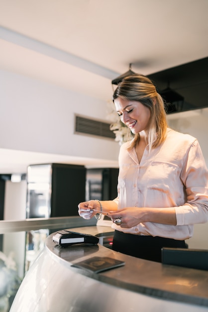 Close up of guest makes card payment at check-in at reception front desk.