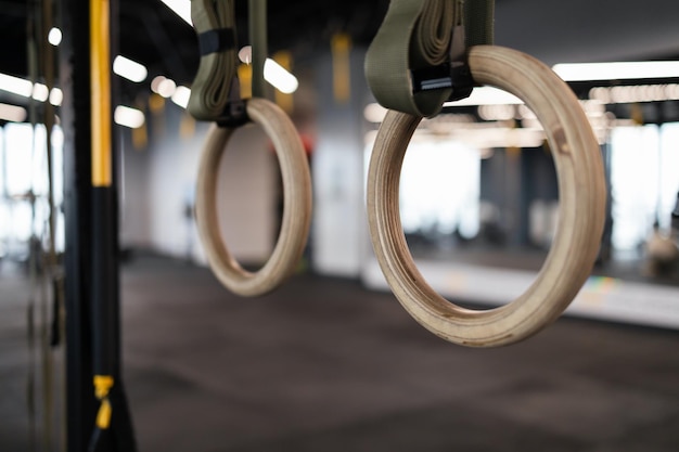 Photo close up gymnastic rings hang in gym.