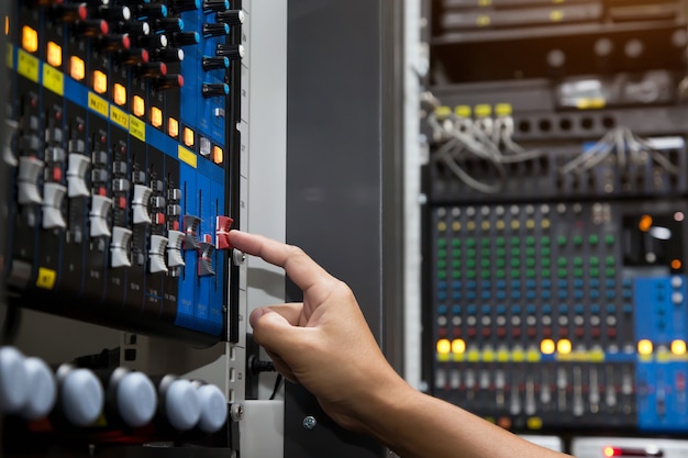 Close-up hand adjust the volume on sound mixer