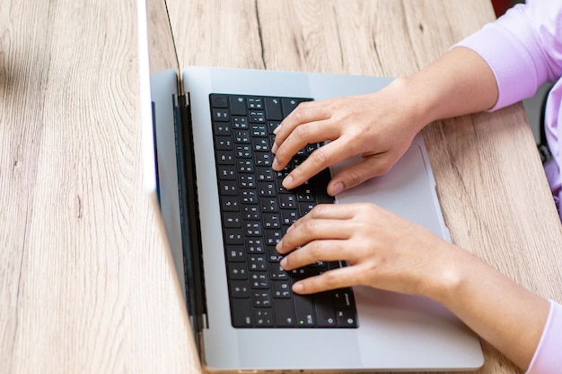 Close up hand of a business woman typing keyboard laptop computer on desk office