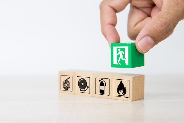 Close-up hand choose wooden blocks with door exit sign.