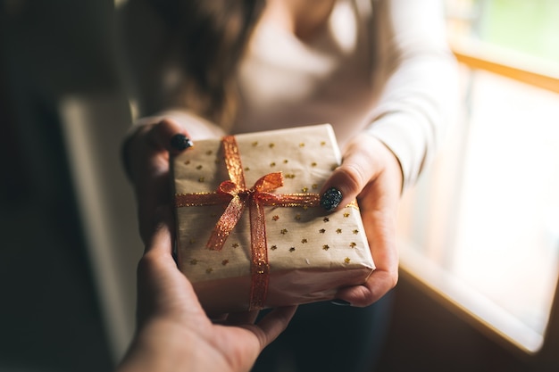 Close up of a hand giving a present to his partner