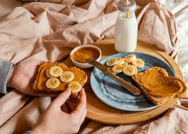 Close-up hand holding bread with peanut butter