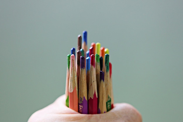 Photo close-up of hand holding colored pencils