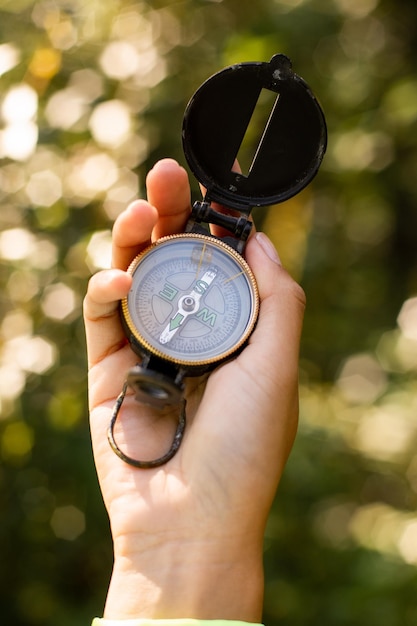 Close up of a hand holding a compass outdoors