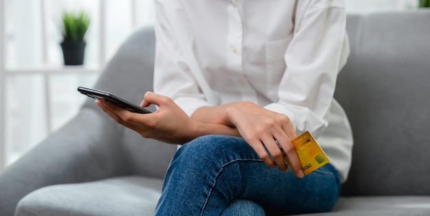 Close up of hand holding credit card with paying online on smartphone in internet store