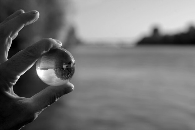 Photo close-up of hand holding crystal ball