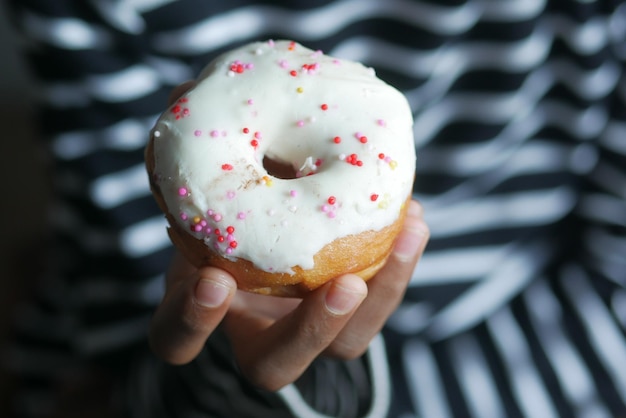 Close up of hand holding donuts