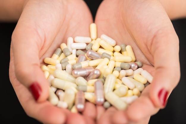 close up hand holding drug on a black background with selective focus