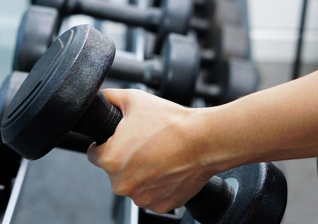 Close up of hand holding dumbbell in fitness