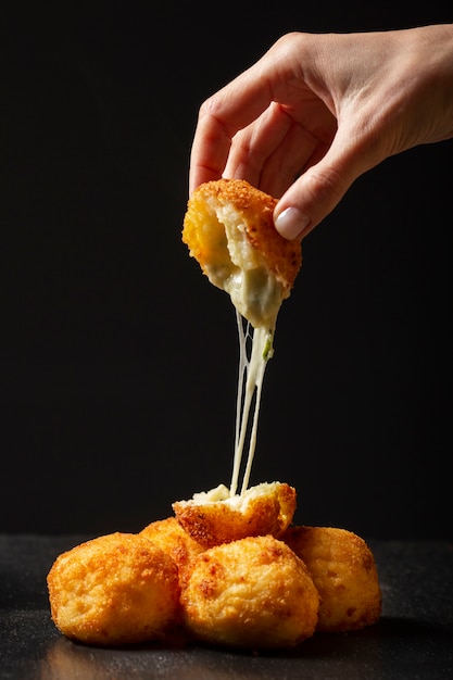 Close up hand holding food croquette