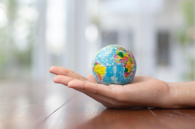 Close-up of hand holding globe on table