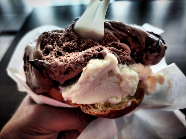 Photo close-up of hand holding ice cream cone