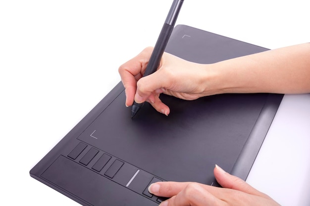 Close up of a hand holding a pen and drawing on a tablet surface retouching