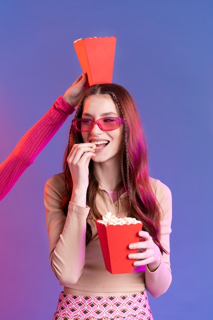 Close up hand holding popcorn bag on girl's hand