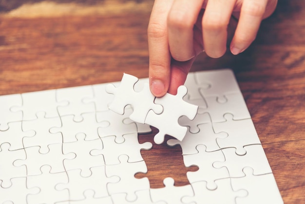 Photo close-up of hand holding puzzle piece