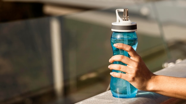 Close-up of hand holding water bottle