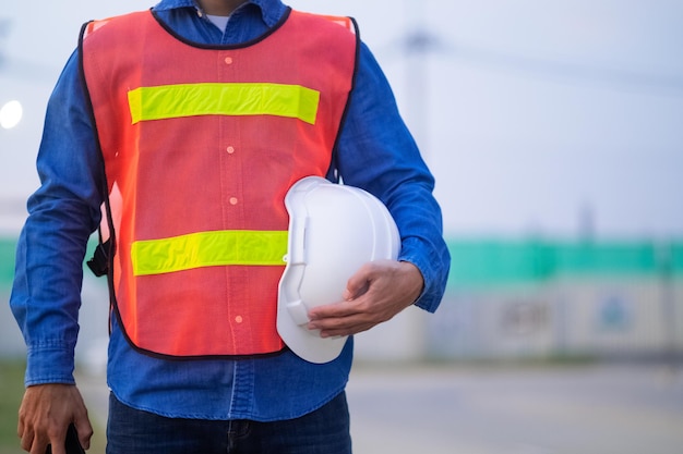 Close up hand holding white helmet hard hat Engineering concept Technician holding hard hat safety hard hat sunlight background