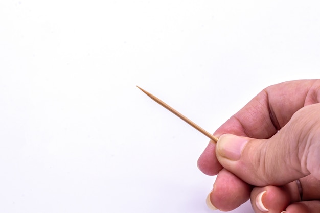 Close up hand holding wooden toothpick isolate.