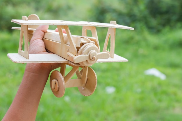 Close-up of hand holding wooden toy plane