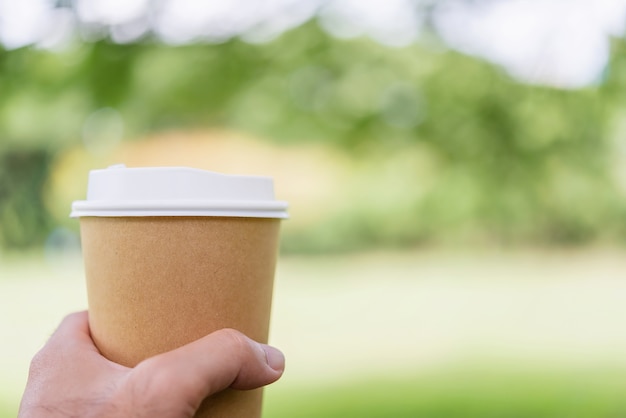 Close up hand of male holding coffee cup.