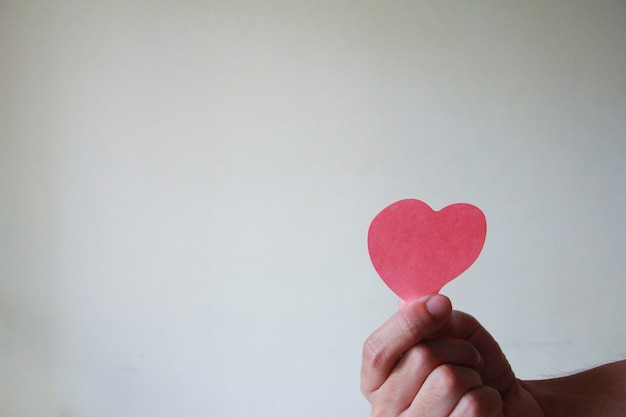 Close up of hand man holding a paper heart. love concept, happy valentine.