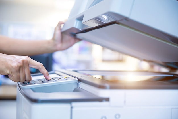 Close up hand of office man press the button on the copier.