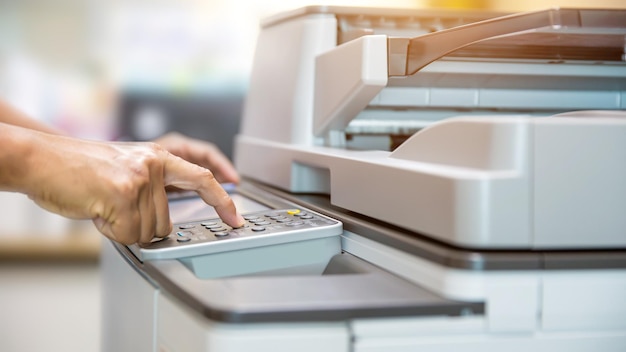 Close up hand of office man press the button on the copier