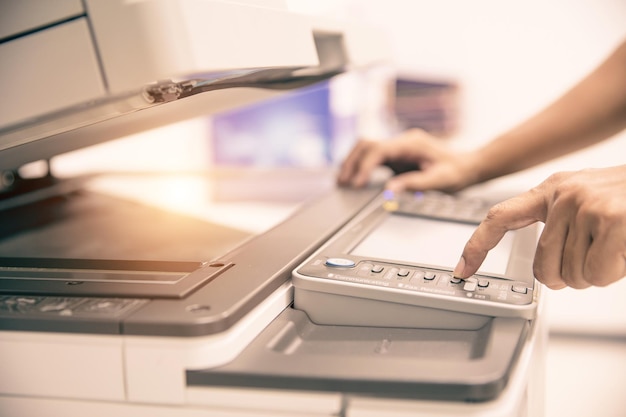 Close up hand office man press copy button on panel to using the photocopier