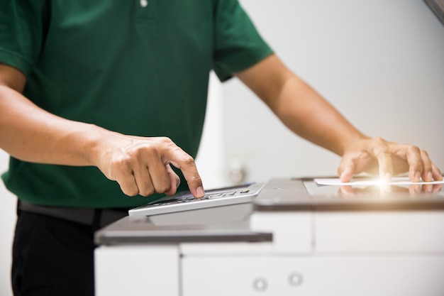 Close up hand office man press copy button on panel to using the photocopier