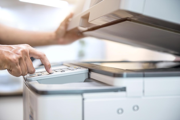 Close up hand office man press copy button on panel to using the photocopier