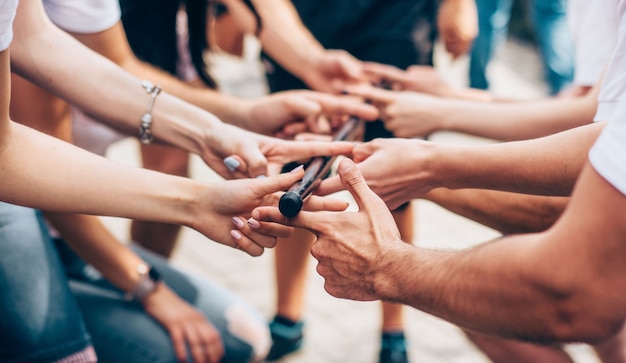 Close-up of the hand of people who are holding stick