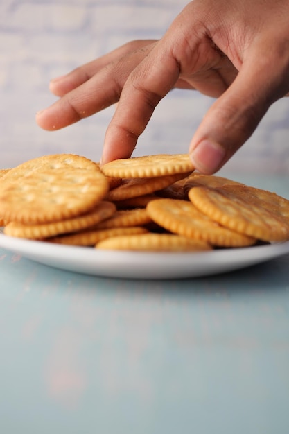 Close up of hand pick sweet cookies on wooden table