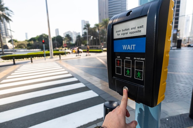 Close up of hand pressing button on pedestrian crossing