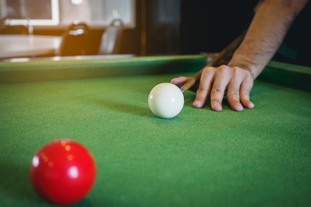 Close up on hand's snooker player and white and red snooker ball or pool on the snooker table The competition snooker game bet Indoor sport concept