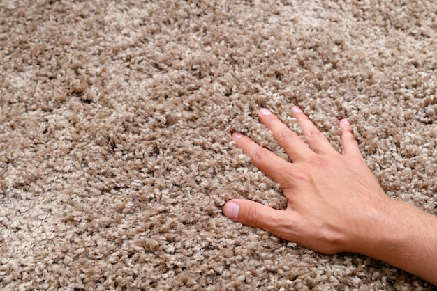 Close up of hand touching soft carpet. Gentle and fluffy carpet.