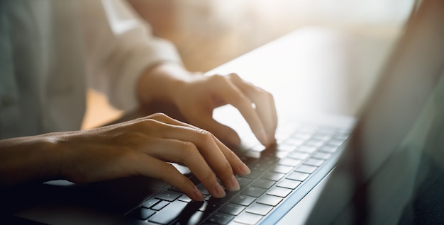 Close up of hand using on keyboard laptop and  typing with social media on internet.