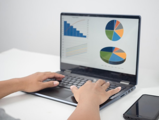 Close up hand using laptop charts graphs business at screen on the table