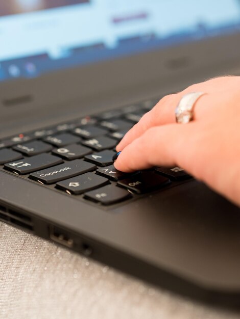 Photo close-up of hand using laptop