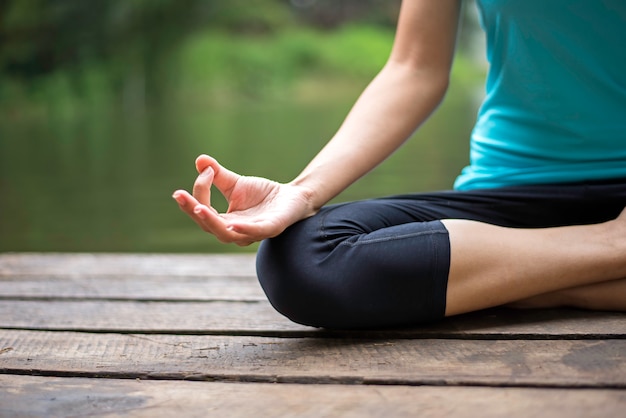 Close up hand. Woman do yoda outdoor. Woman exercising yoga at the nature background