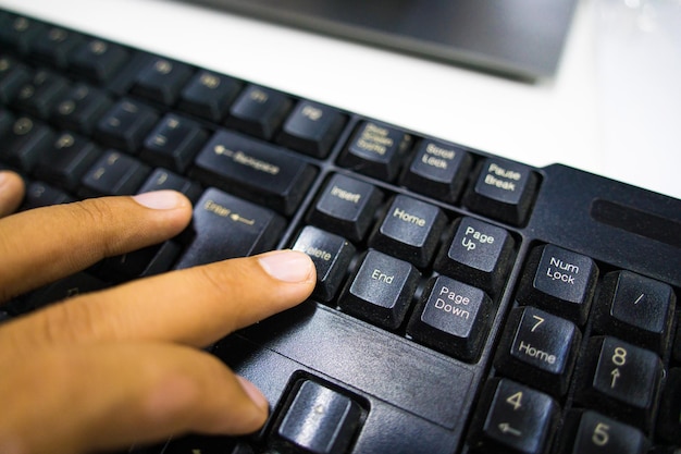 Close up hand of young man working on laptop computer with digital tablet on desk at home or coffee